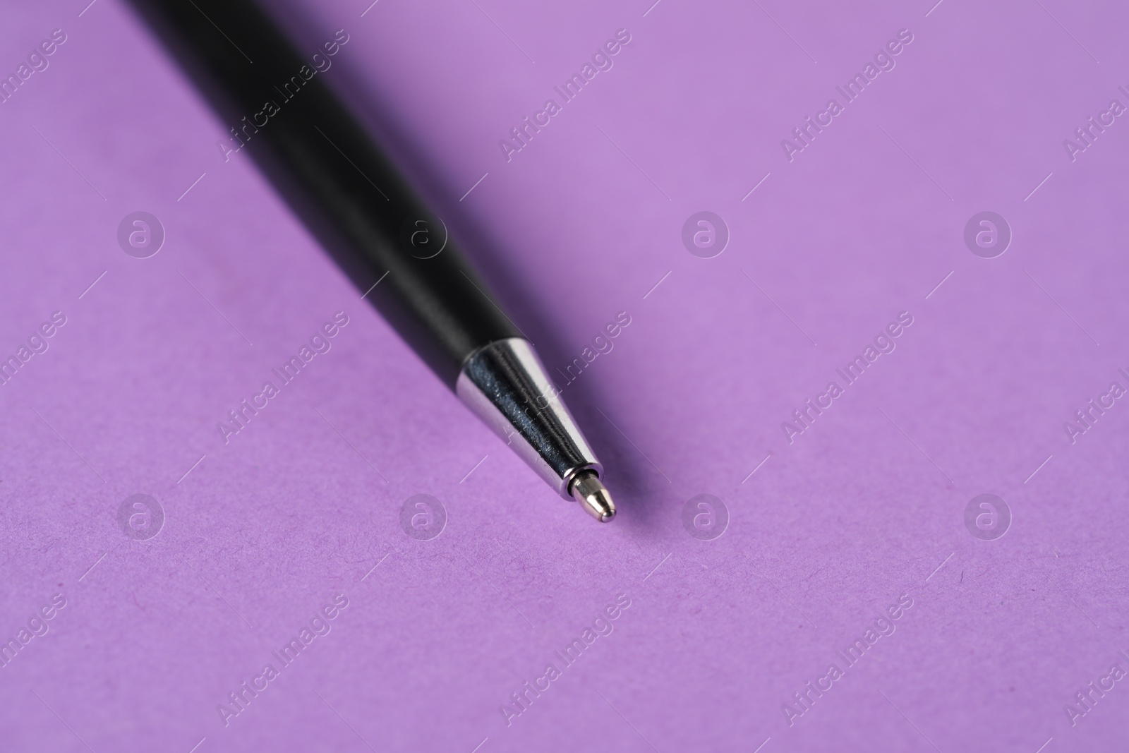 One stylish pen on violet background, macro view. Space for text Photo of One stylish pen on violet background, macro view. Space for text