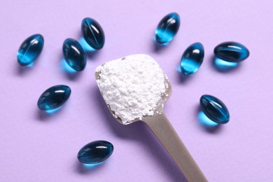 Photo of Collagen capsules and spoon with powder on violet background, flat lay