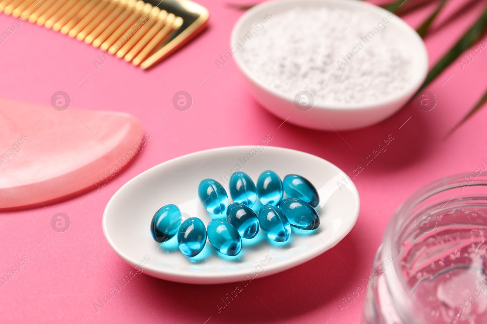 Collagen capsules, powder, gel, comb and gua sha on pink background, closeup Photo of Collagen capsules, powder, gel, comb and gua sha on pink background, closeup