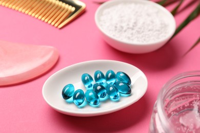 Photo of Collagen capsules, powder, gel, comb and gua sha on pink background, closeup