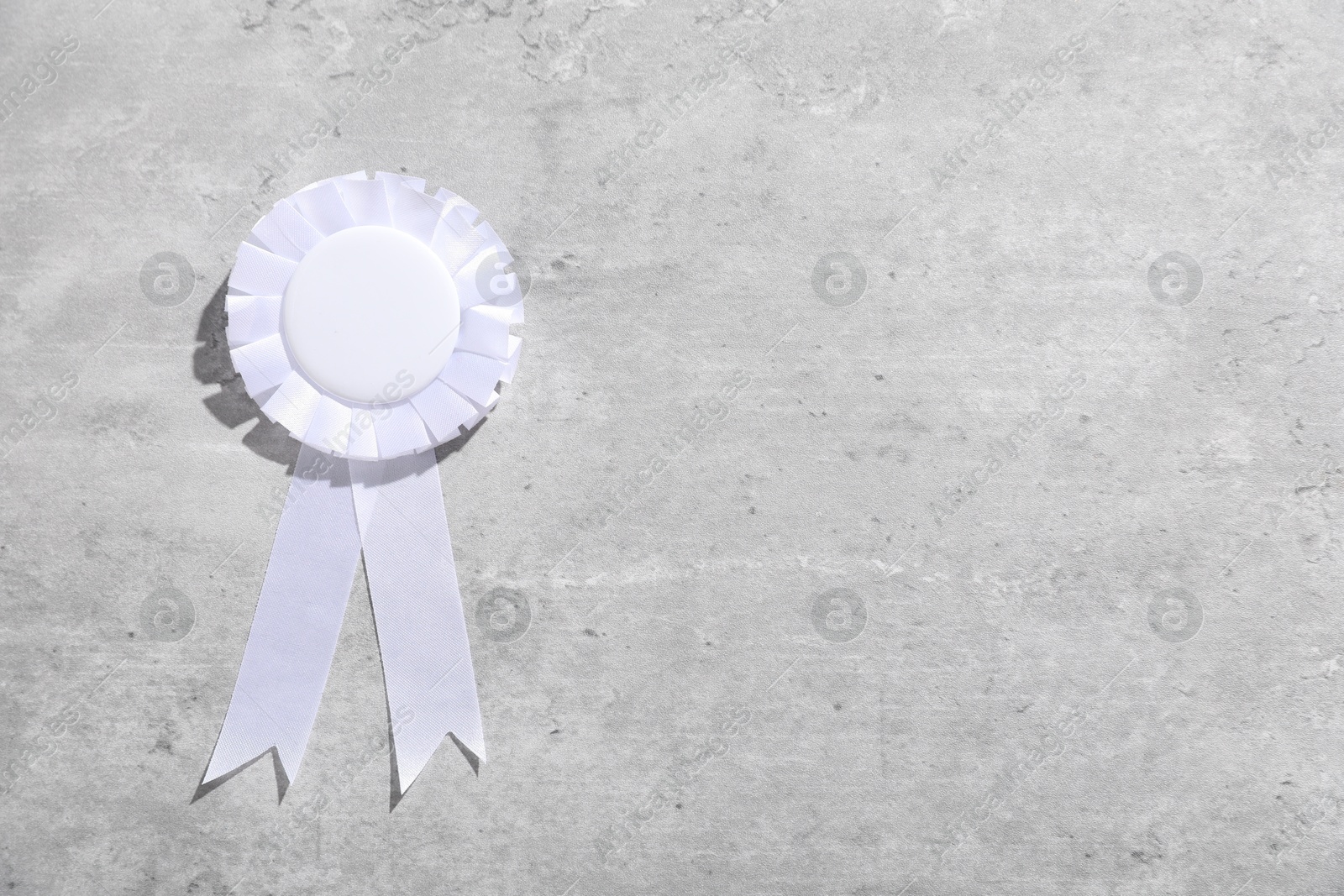 White award ribbon on light grey table, top view. Space for text Photo of White award ribbon on light grey table, top view. Space for text