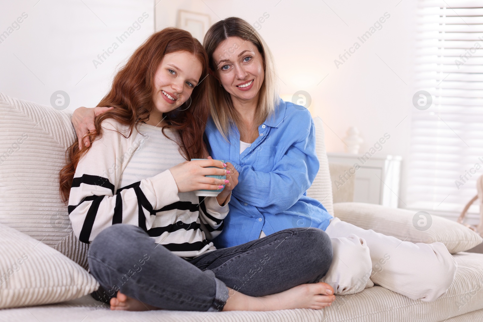 Mother and her daughter on sofa at home Photo of Mother and her daughter on sofa at home
