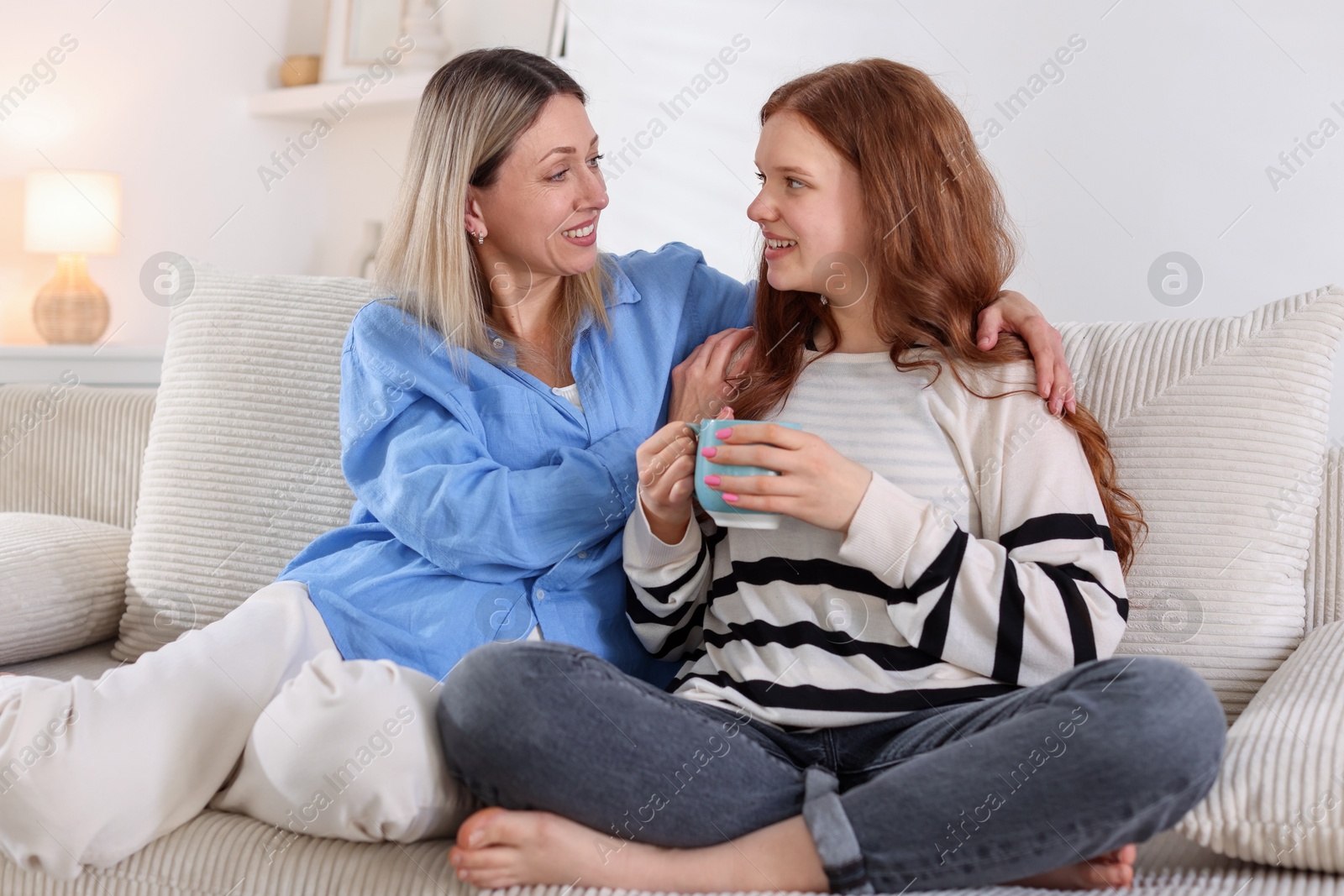 Mother and her daughter on sofa at home Photo of Mother and her daughter on sofa at home