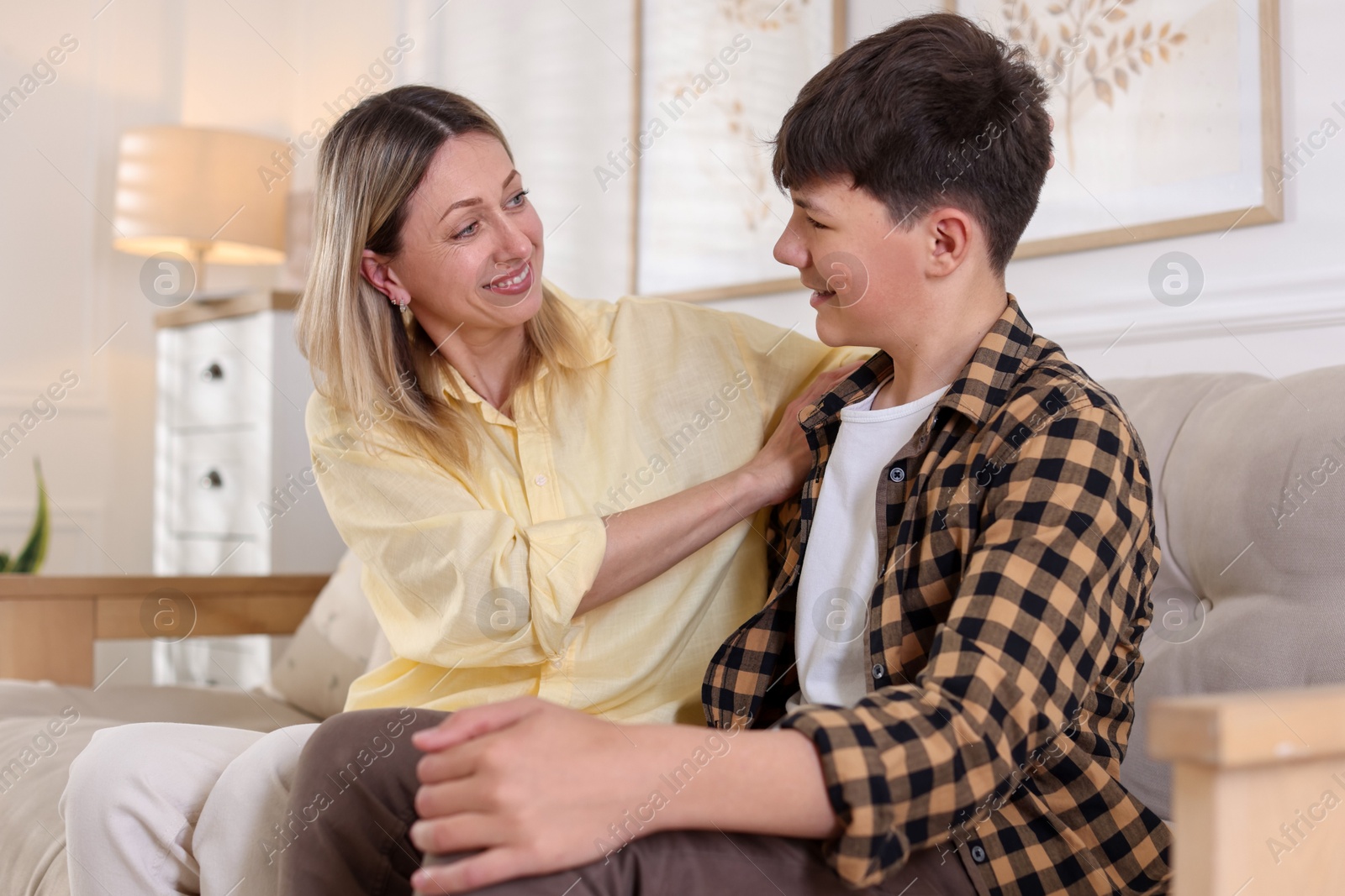 Mother and her son on sofa at home Photo of Mother and her son on sofa at home