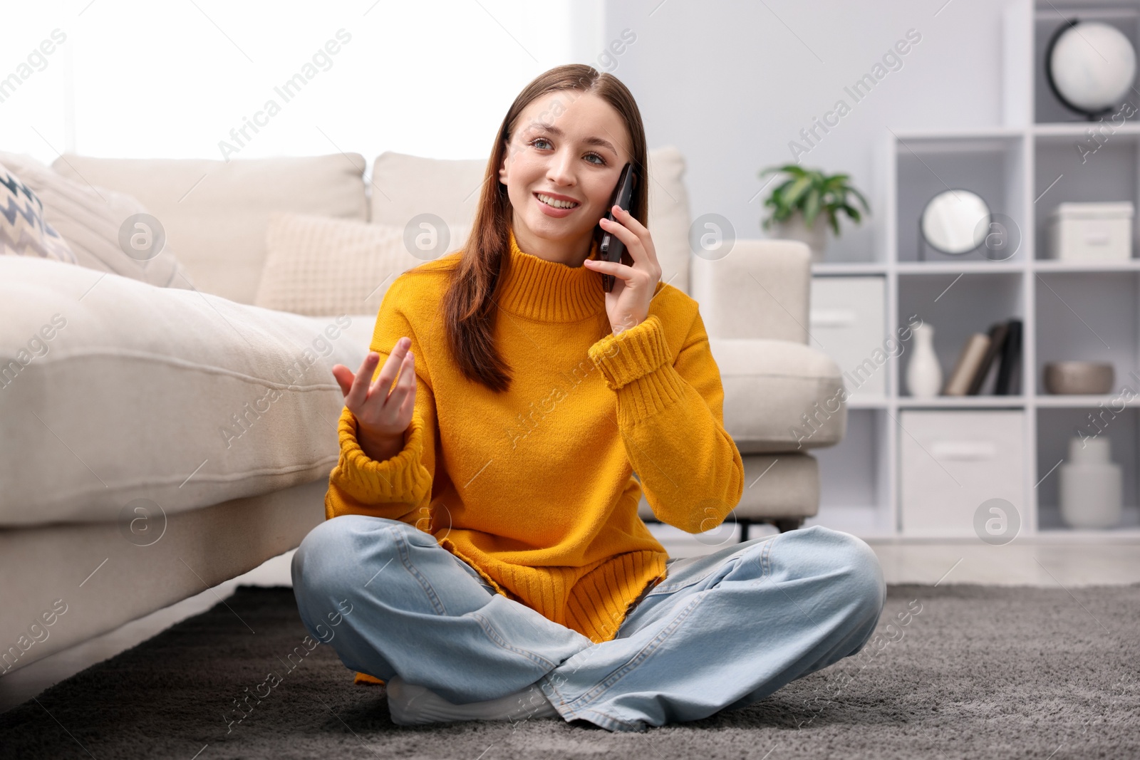 Teenage girl talking on smartphone at home Photo of Teenage girl talking on smartphone at home