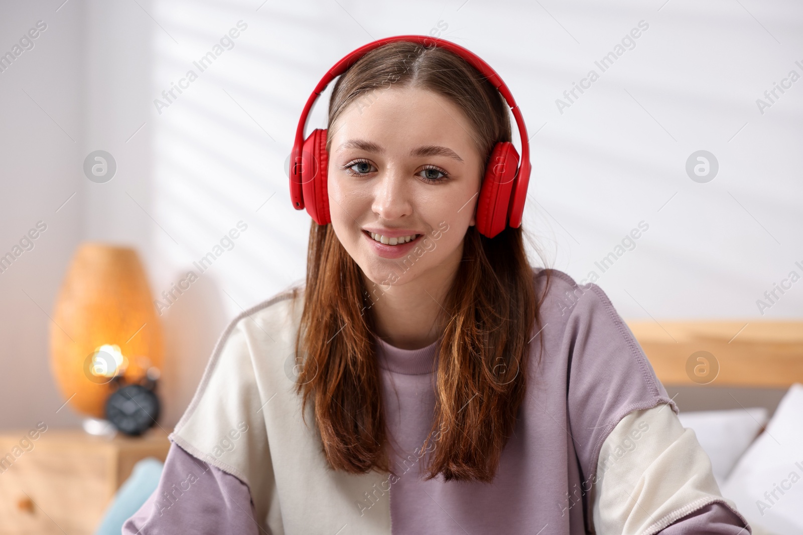 Teenage girl in headphones listening to music at home Photo of Teenage girl in headphones listening to music at home