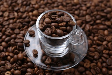 Photo of Cup and saucer on coffee beans, closeup