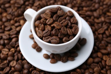 Photo of Cup and saucer on coffee beans, closeup