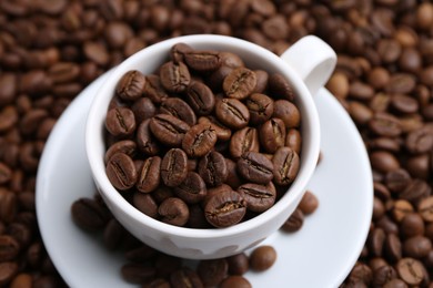 Photo of Cup and saucer on coffee beans, above view