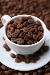 Photo of Cup and saucer on coffee beans, closeup