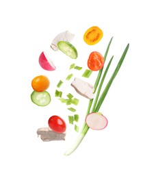Image of Pieces of chicken meat and fresh vegetables falling on white background