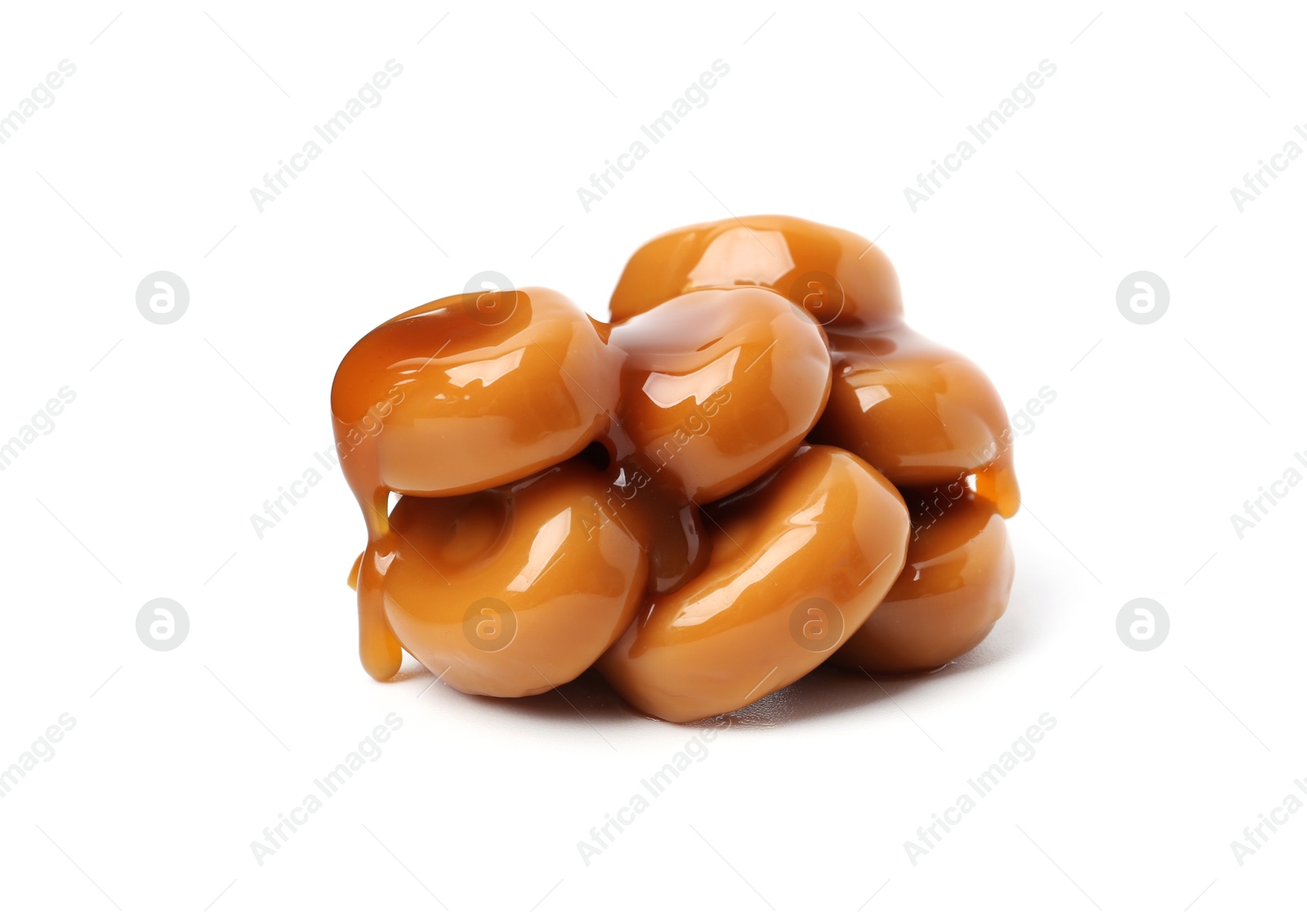 Tasty sweet candies and caramel sauce isolated on white Photo of Tasty sweet candies and caramel sauce isolated on white