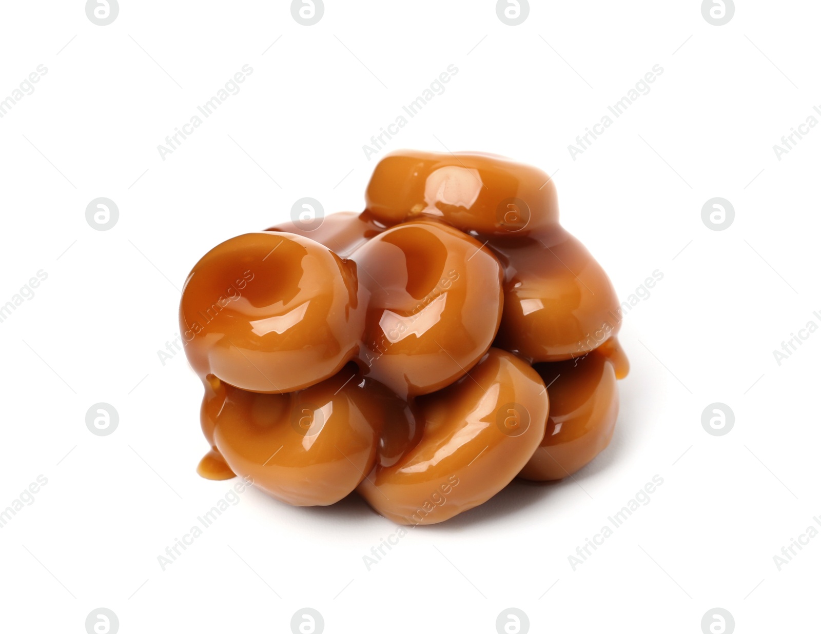 Tasty sweet candies and caramel sauce isolated on white Photo of Tasty sweet candies and caramel sauce isolated on white