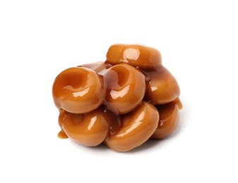 Photo of Tasty sweet candies and caramel sauce isolated on white
