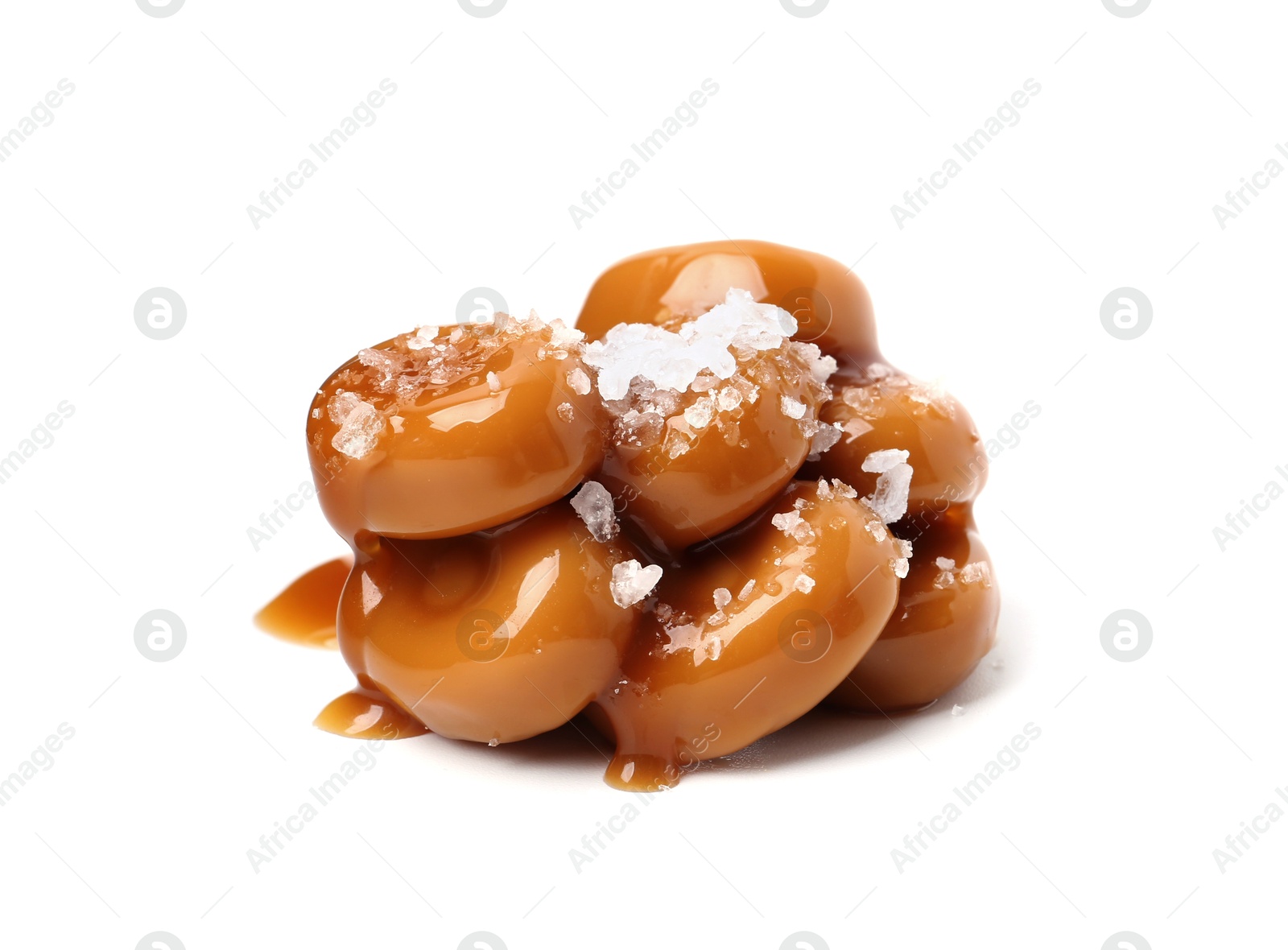 Tasty sweet candies, salt and caramel sauce isolated on white Photo of Tasty sweet candies, salt and caramel sauce isolated on white