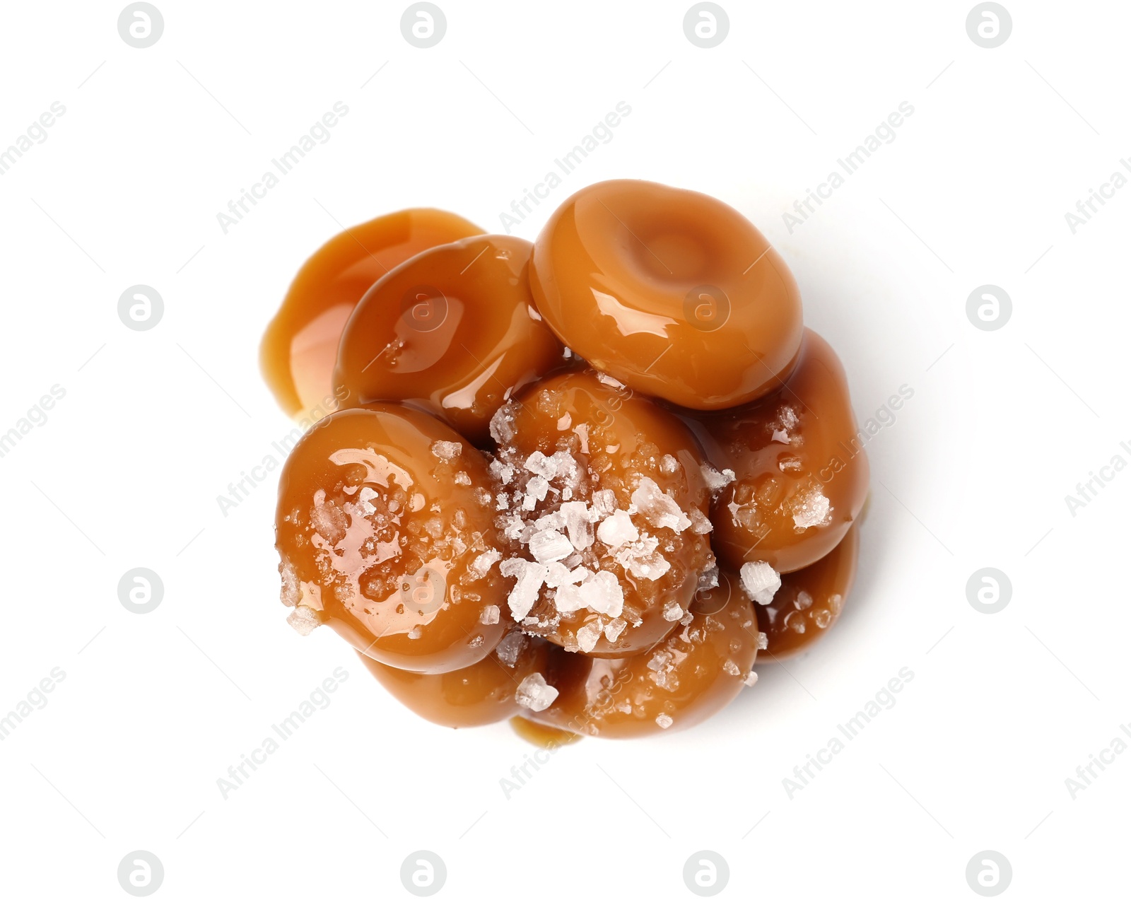 Tasty sweet candies, salt and caramel sauce isolated on white, top view Photo of Tasty sweet candies, salt and caramel sauce isolated on white, top view