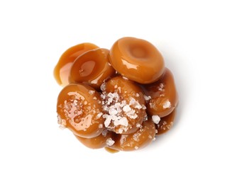 Photo of Tasty sweet candies, salt and caramel sauce isolated on white, top view