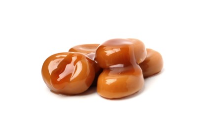 Photo of Tasty sweet candies and caramel sauce isolated on white