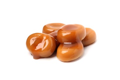 Photo of Tasty sweet candies and caramel sauce isolated on white