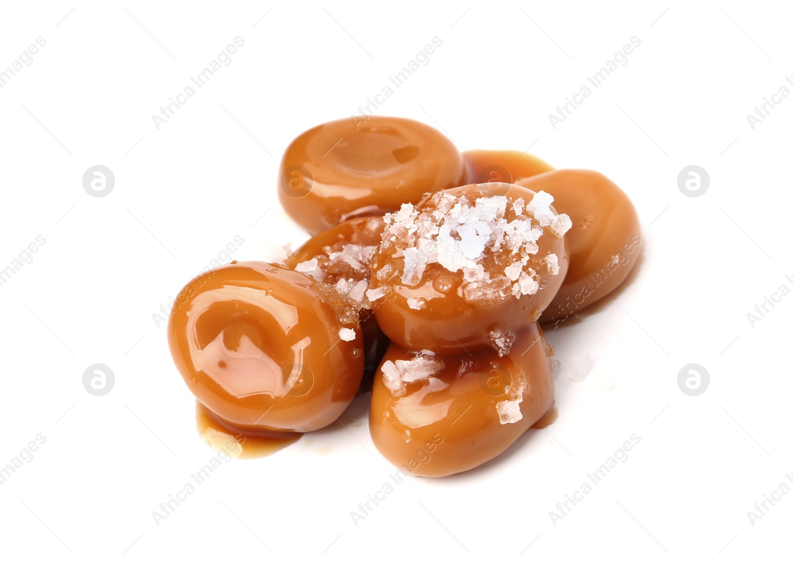 Tasty sweet candies, salt and caramel sauce isolated on white Photo of Tasty sweet candies, salt and caramel sauce isolated on white
