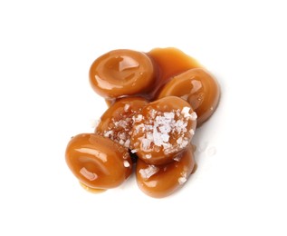 Photo of Tasty sweet candies, salt and caramel sauce isolated on white, top view