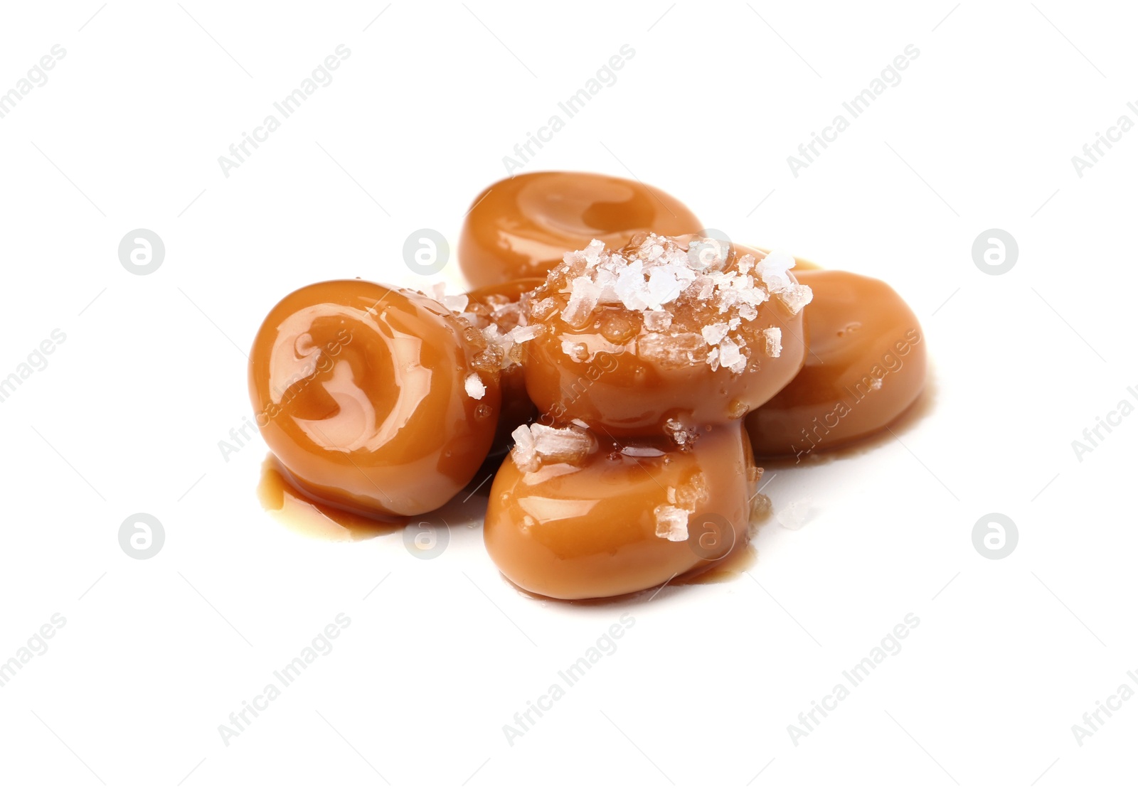 Tasty sweet candies, salt and caramel sauce isolated on white Photo of Tasty sweet candies, salt and caramel sauce isolated on white