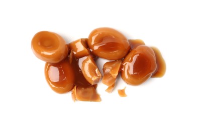 Photo of Tasty sweet candies and caramel sauce isolated on white, top view