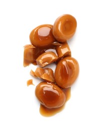 Photo of Tasty sweet candies and caramel sauce isolated on white, top view