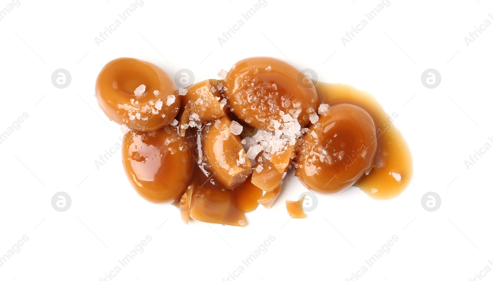 Tasty sweet candies, salt and caramel sauce isolated on white, top view Photo of Tasty sweet candies, salt and caramel sauce isolated on white, top view