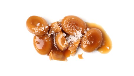 Photo of Tasty sweet candies, salt and caramel sauce isolated on white, top view
