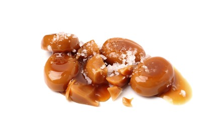 Photo of Tasty sweet candies, salt and caramel sauce isolated on white