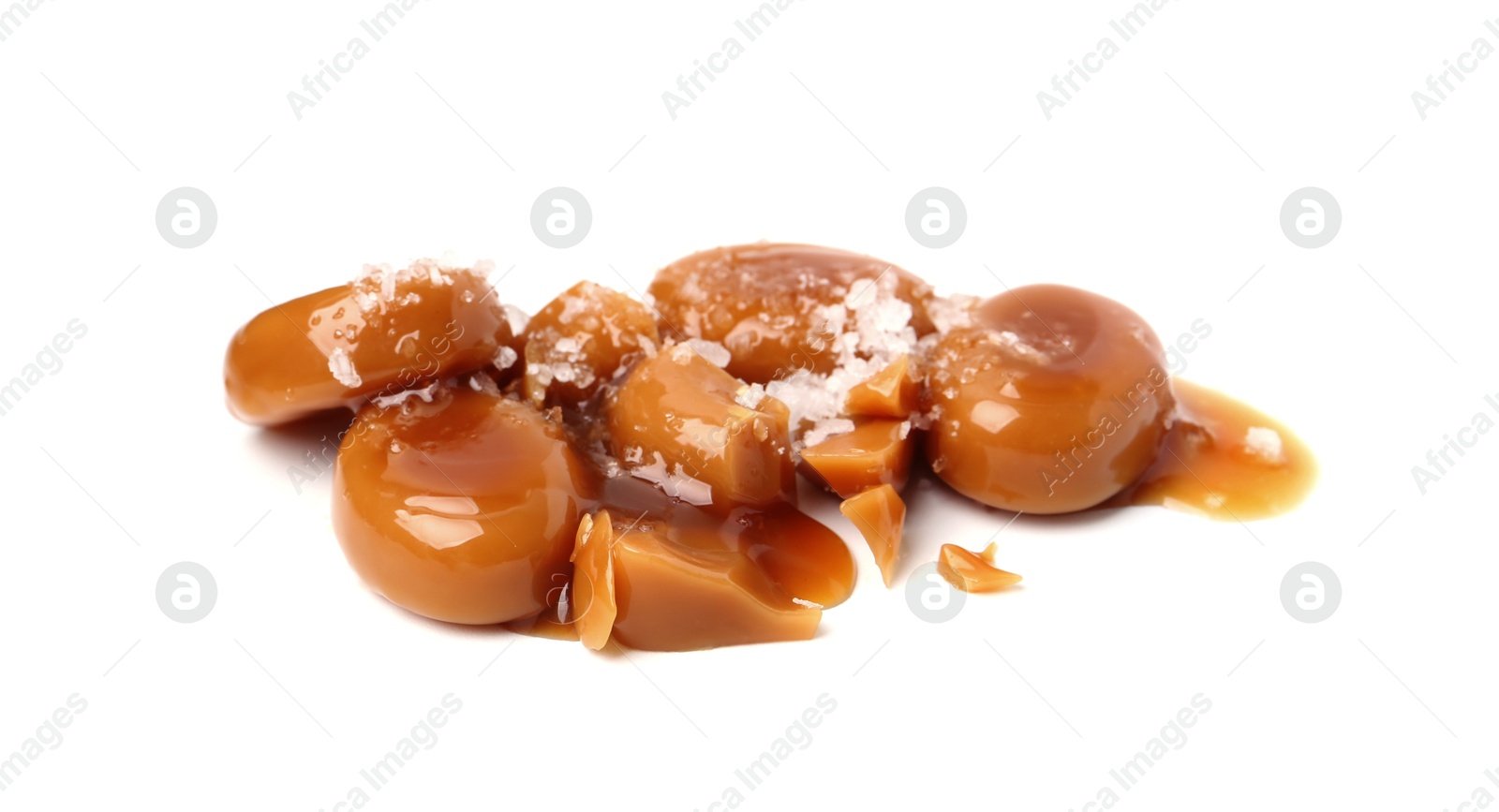 Tasty sweet candies, salt and caramel sauce isolated on white Photo of Tasty sweet candies, salt and caramel sauce isolated on white