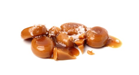 Photo of Tasty sweet candies, salt and caramel sauce isolated on white