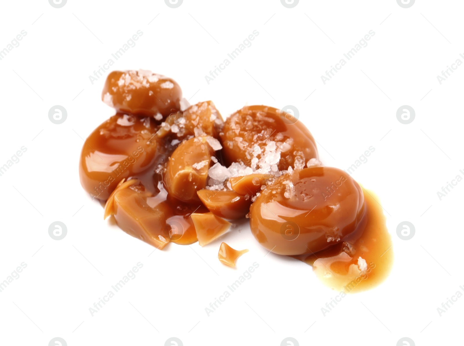 Tasty sweet candies, salt and caramel sauce isolated on white Photo of Tasty sweet candies, salt and caramel sauce isolated on white