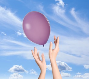 Image of Woman letting balloon out of her hands into sky, closeup. Freedom concept