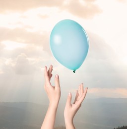 Image of Woman letting balloon out of her hands into sky, closeup. Freedom concept