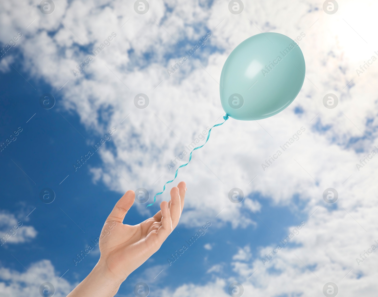 Man letting balloon out of his hand into sky, closeup. Freedom concept Image of Man letting balloon out of his hand into sky, closeup. Freedom concept