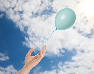 Image of Man letting balloon out of his hand into sky, closeup. Freedom concept
