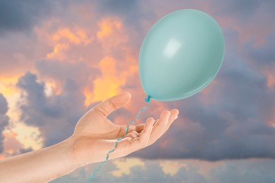 Image of Man letting balloon out of his hand into sky, closeup. Freedom concept