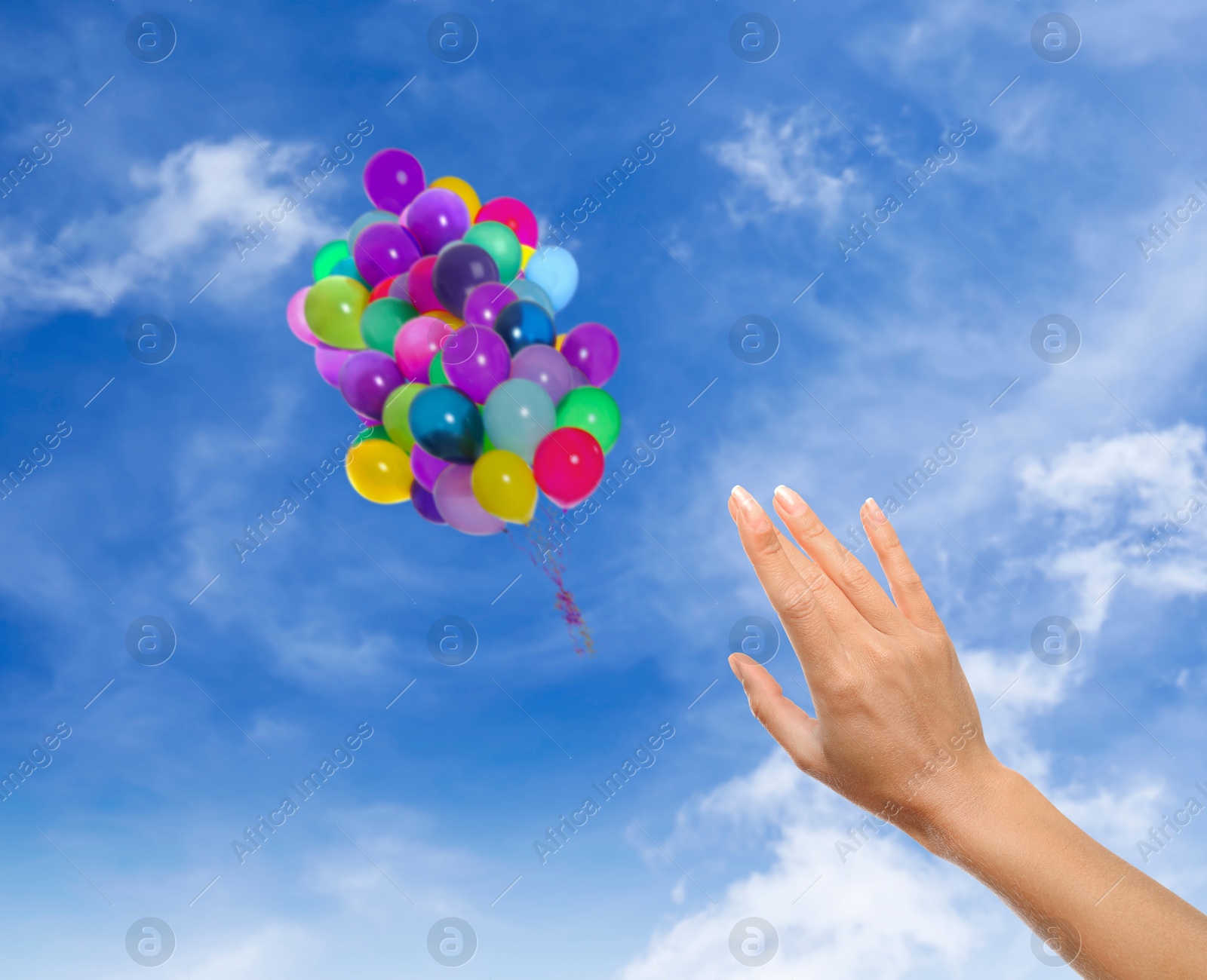 Woman let go bunch of balloons out of her hand into sky, closeup. Freedom concept Image of Woman let go bunch of balloons out of her hand into sky, closeup. Freedom concept