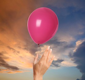 Image of Woman letting balloon out of her hand into sky, closeup. Freedom concept