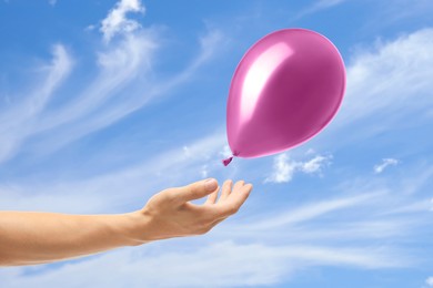 Image of Man letting balloon out of his hand into sky, closeup. Freedom concept