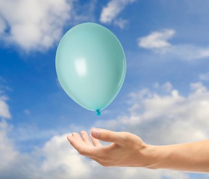 Image of Man letting balloon out of his hand into sky, closeup. Freedom concept