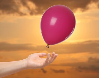 Image of Man letting balloon out of his hand into sky, closeup. Freedom concept