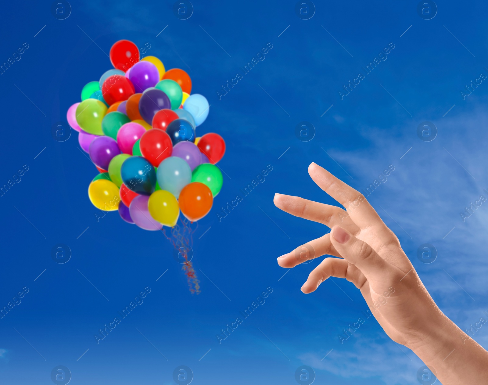 Woman let go bunch of balloons out of her hand into sky, closeup. Freedom concept Image of Woman let go bunch of balloons out of her hand into sky, closeup. Freedom concept