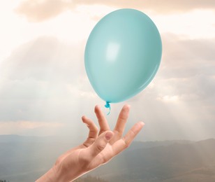 Image of Woman letting balloon out of her hand into sky, closeup. Freedom concept