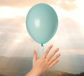 Image of Child letting balloon out of hand into sky, closeup. Freedom concept