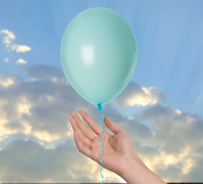 Image of Woman letting balloon out of her hand into sky, closeup. Freedom concept