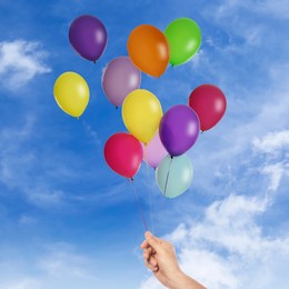 Image of Man is about to let bunch of balloons out of his hand into sky, closeup. Freedom concept