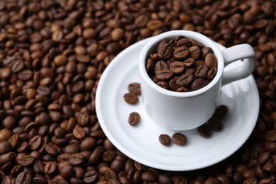 Photo of Cup and saucer on coffee beans, closeup. Space for text